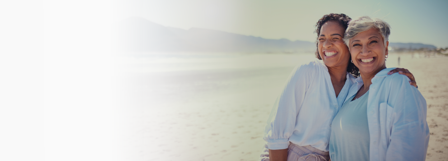 two women smiling at the beach