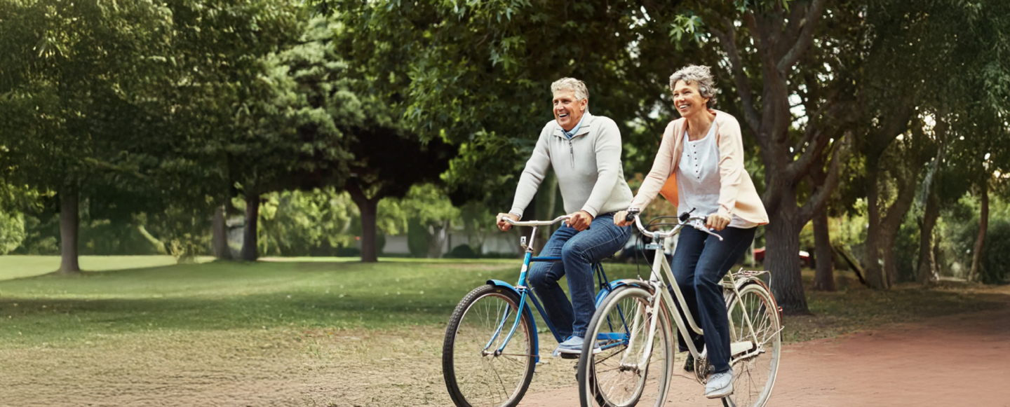 Man and Women biking through the park