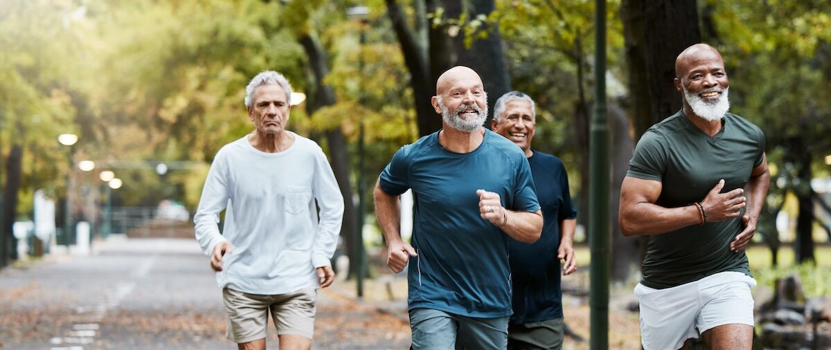 Senior, man group and running on street together for elderly fitness and urban wellness with happiness. Happy retirement, smile and runner club in workout, diversity and teamwork in park for health.