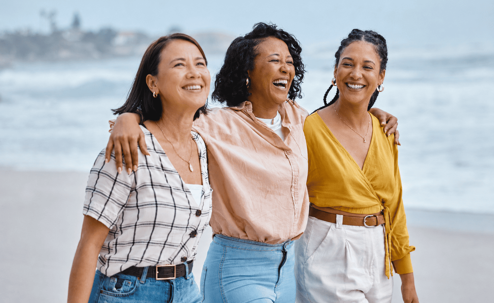 three people on the beach smiling